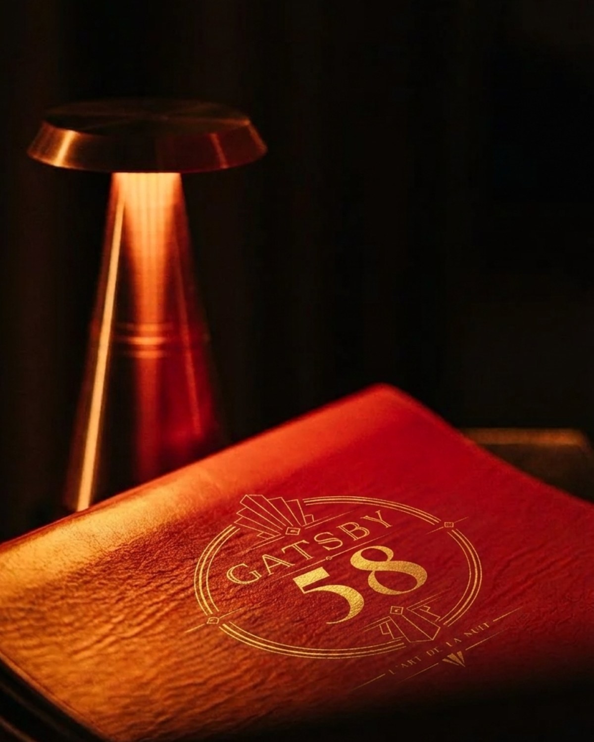 Le menu en cuir rouge Gatsby 58 sous une lumière ambrée